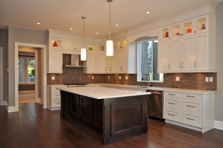 Design ideas for a large transitional u-shaped eat-in kitchen in Vancouver with an undermount sink, beaded inset cabinets, white cabinets, quartz benchtops, brown splashback, matchstick tile splashback, stainless steel appliances, dark hardwood floors, with island, brown floor and white benchtop.