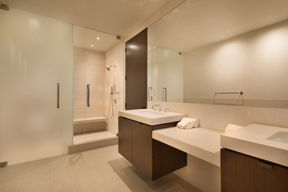 Photo of a mid-sized contemporary bathroom in Denver with flat-panel cabinets, dark wood cabinets, a corner shower, white tile, stone tile, white walls, a wall-mount sink and terrazzo benchtops.
