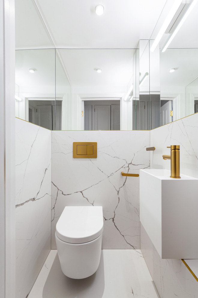 Small contemporary cloakroom in London with white cabinets, a wall mounted toilet, white tiles, porcelain tiles, white walls, porcelain flooring, a wall-mounted sink, white floors, a feature wall and a floating vanity unit.