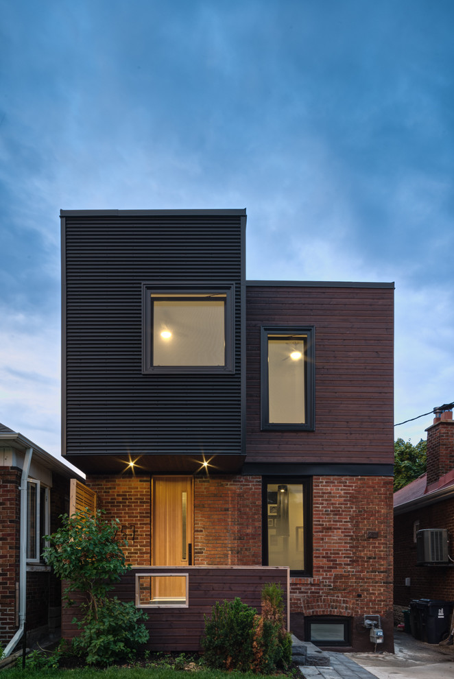 Contemporary two-storey black exterior in Toronto with mixed siding and a flat roof.