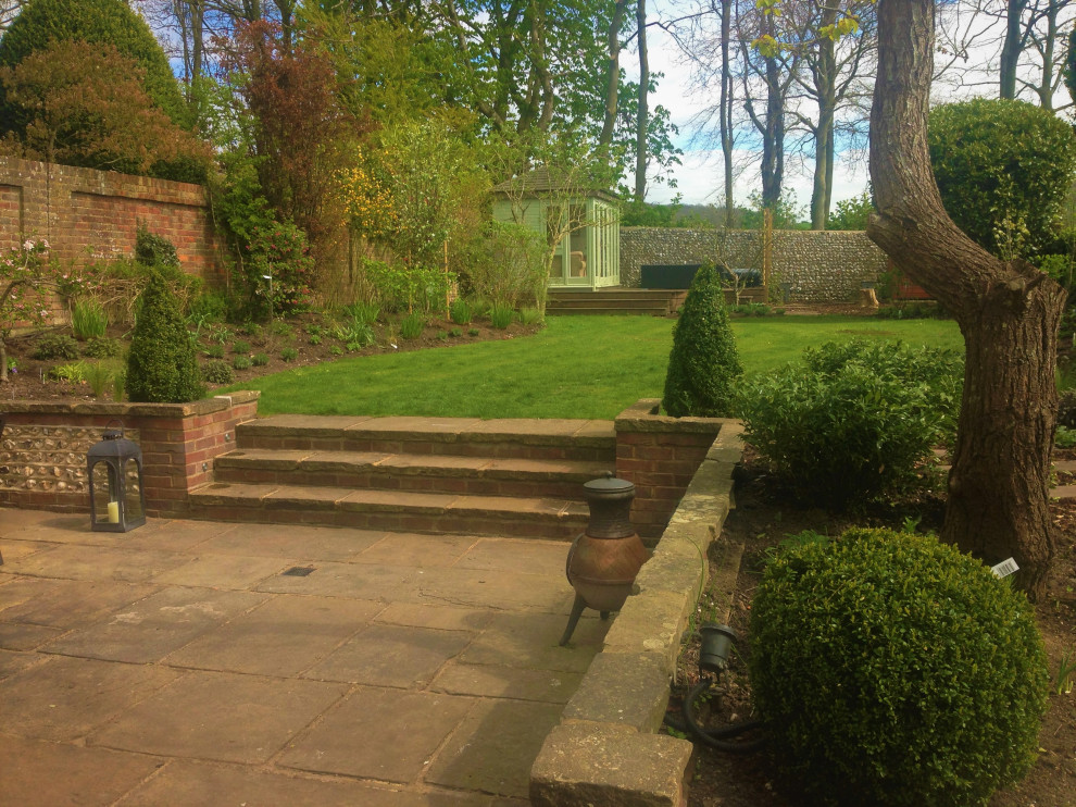 Idee per un orto in giardino country esposto in pieno sole di medie dimensioni e dietro casa in estate con pavimentazioni in pietra naturale e recinzione in legno