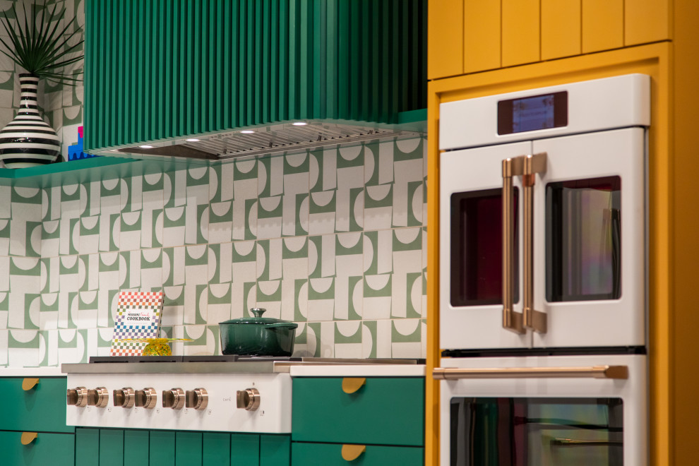 Стильный дизайн: большая угловая кухня в стиле модернизм с обеденным столом, бирюзовыми фасадами и зеленым фартуком - последний тренд