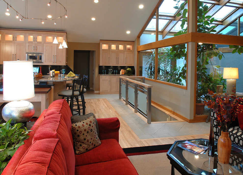 Exempel på ett mellanstort modernt flerfärgad flerfärgat kök, med en undermonterad diskho, skåp i shakerstil, skåp i ljust trä, granitbänkskiva, svart stänkskydd, rostfria vitvaror, ljust trägolv, en köksö och brunt golv