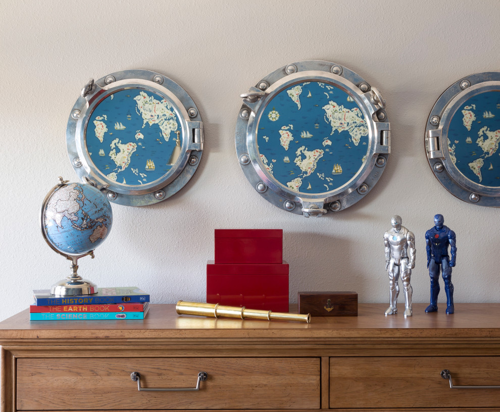 Mapping the World - A trio of authentic port holes from a salvaged ship reflect the maps of the world wallpaper.   The warm wood dresser is timeless and provides ample storage.