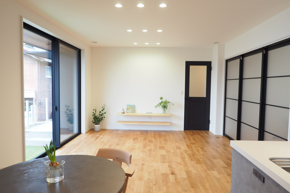 Idee per un soggiorno moderno con pareti bianche, parquet chiaro, pavimento beige e soffitto in carta da parati