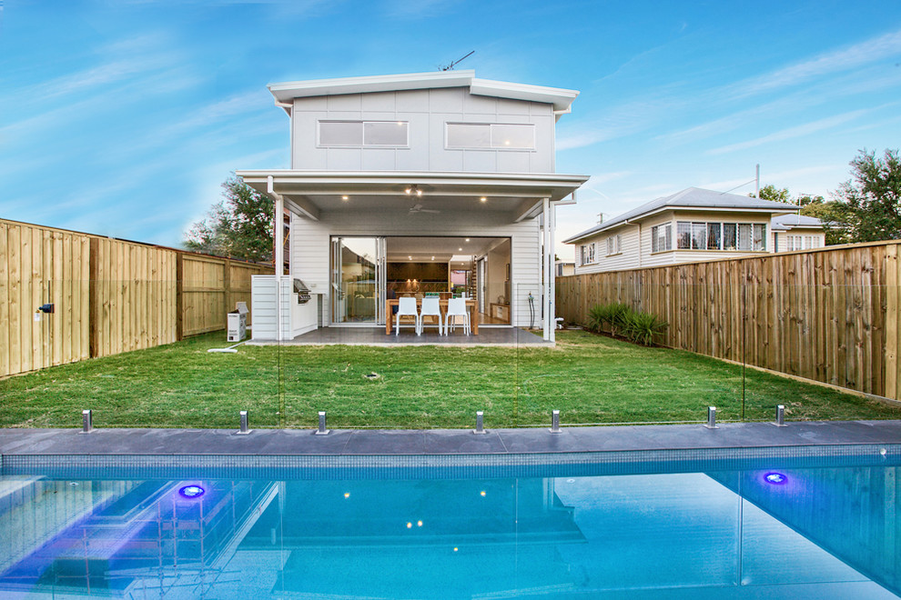 This is an example of a scandinavian backyard rectangular lap pool in Brisbane with concrete pavers.