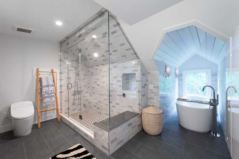 Inspiration for a beach style master bathroom in New York with a freestanding tub, gray tile, white walls and grey floor.
