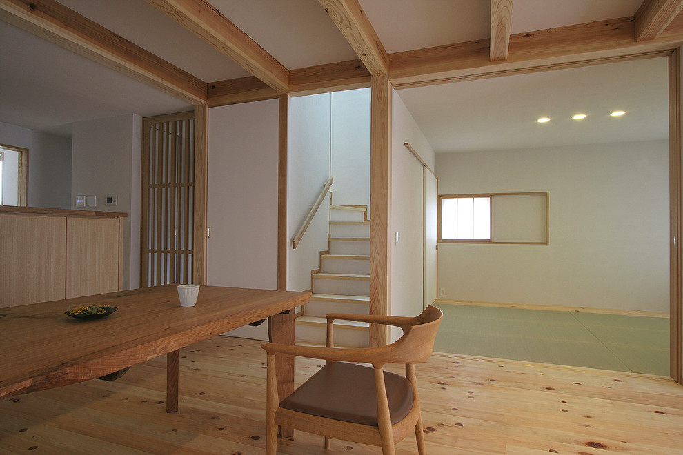 Mid-sized asian open concept living room in Tokyo with white walls, light hardwood floors and a freestanding tv.