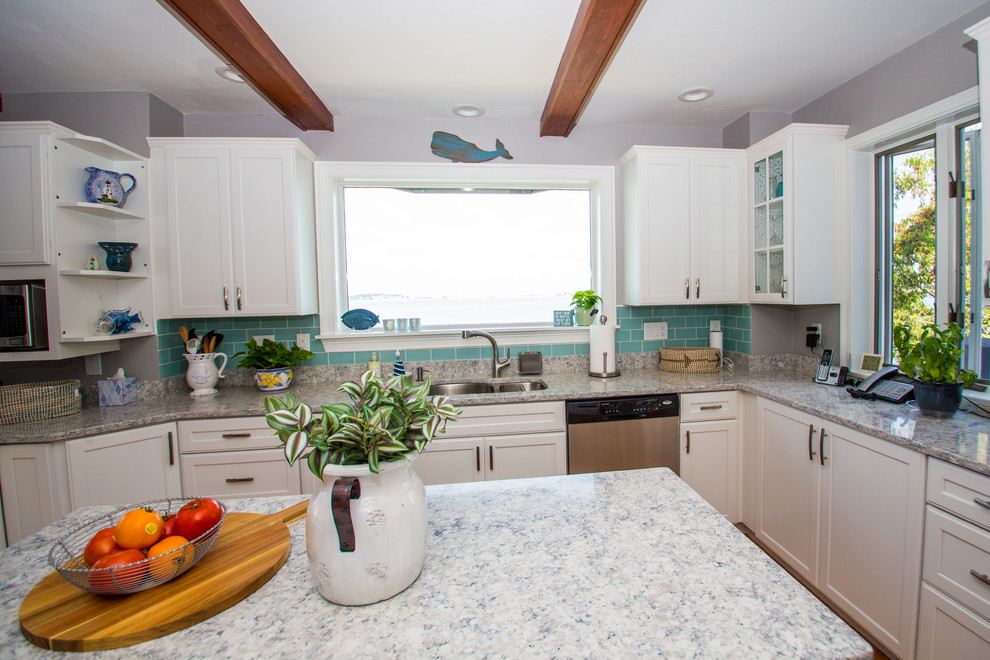 Photo of a mid-sized beach style u-shaped eat-in kitchen in Boston with flat-panel cabinets, white cabinets, quartz benchtops, blue splashback, glass tile splashback, stainless steel appliances, with island, white benchtop, an undermount sink, medium hardwood floors and brown floor.