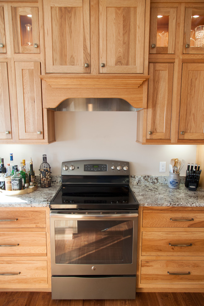 Inspiration for a mid-sized rustic u-shaped medium tone wood floor eat-in kitchen remodel with an undermount sink, shaker cabinets, light wood cabinets, granite countertops, stainless steel appliances and a peninsula
