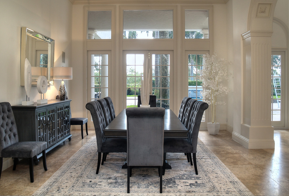 This is an example of a traditional dining room in Miami with ceramic floors, no fireplace, beige floor and white walls.