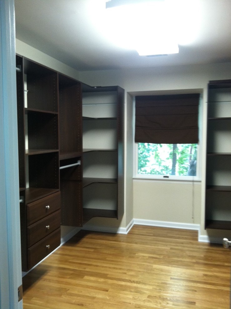 Inspiration for a large modern gender-neutral walk-in wardrobe in Philadelphia with raised-panel cabinets, dark wood cabinets and medium hardwood floors.