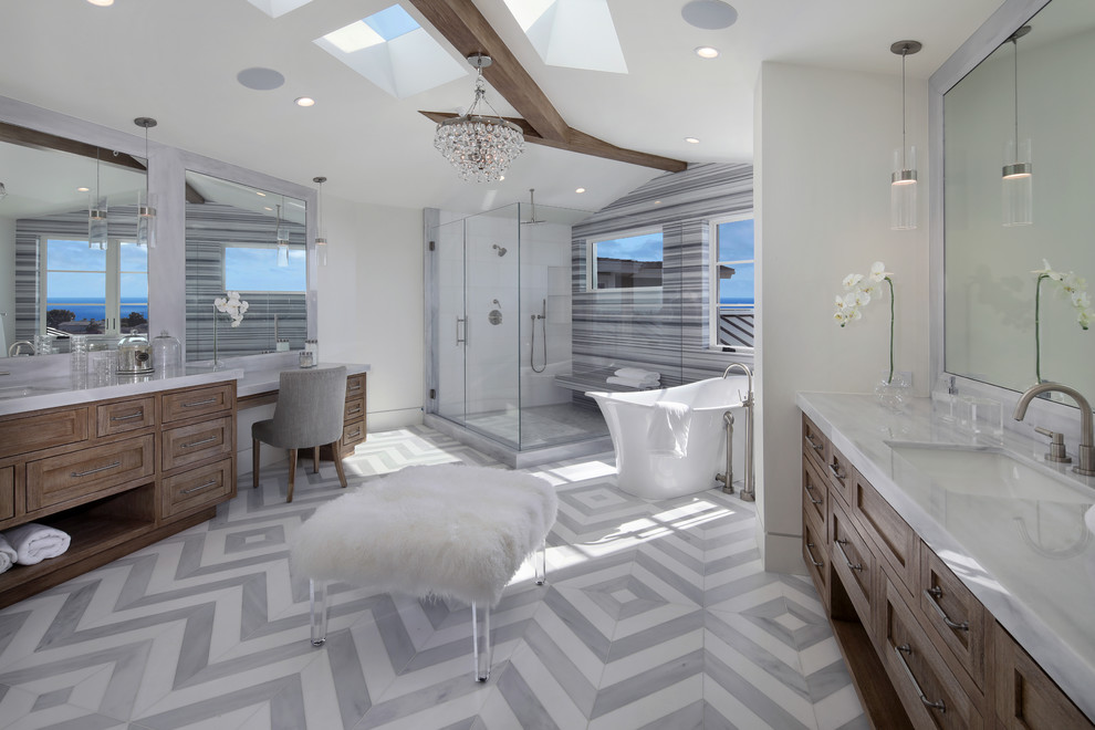 Design ideas for a transitional master bathroom in Los Angeles with shaker cabinets, medium wood cabinets, a freestanding tub, a corner shower, gray tile, white walls, an undermount sink, grey floor and a hinged shower door.