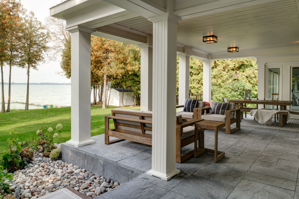 Elegant backyard ground level deck photo in Other with a fire pit and a roof extension