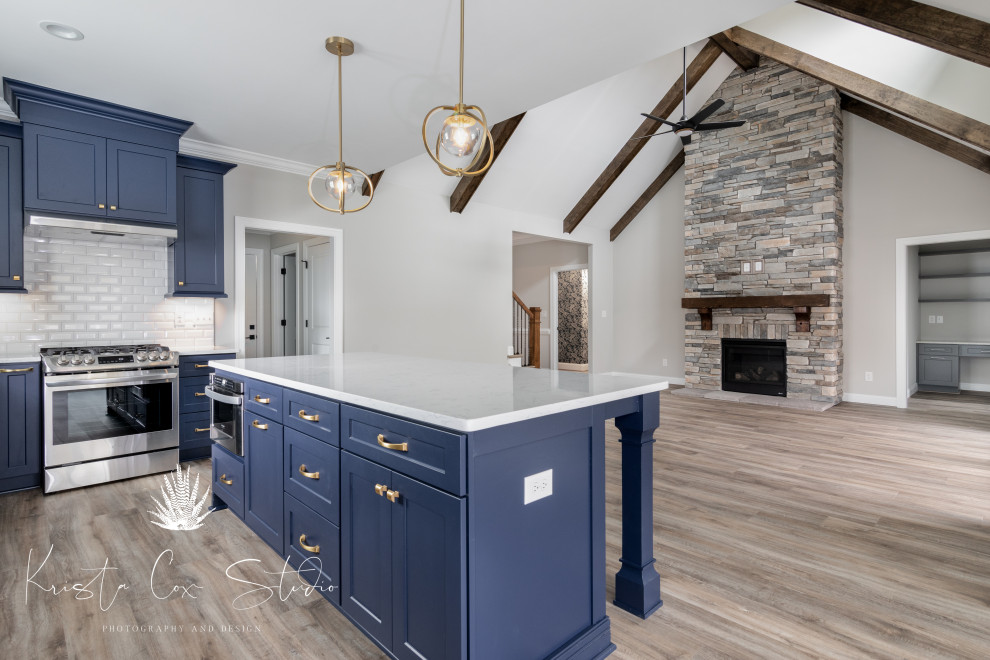 Transitional kitchen photo with shaker cabinets, blue cabinets and an island