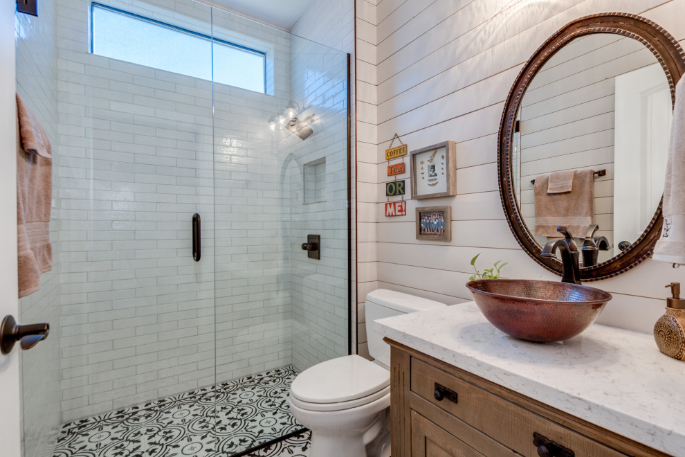 Example of a mid-sized transitional 3/4 white tile multicolored floor and single-sink alcove shower design in Phoenix with shaker cabinets, medium tone wood cabinets, a two-piece toilet, white walls, a vessel sink, a hinged shower door, white countertops, a niche and a built-in vanity