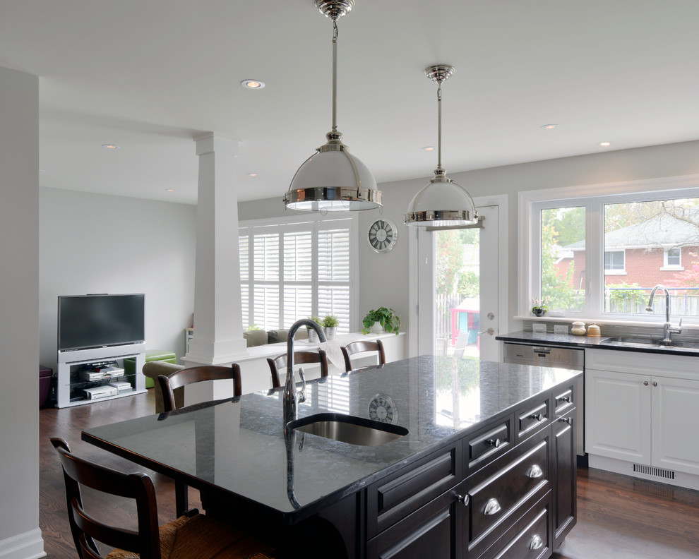 Inspiration for a mid-sized transitional l-shaped dark wood floor eat-in kitchen remodel in Ottawa with a single-bowl sink, raised-panel cabinets, white cabinets, granite countertops, gray backsplash, ceramic backsplash, stainless steel appliances and an island