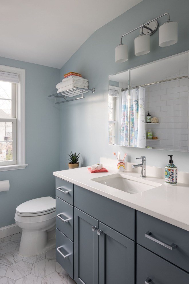 Cette image montre une petite salle de bain traditionnelle pour enfant avec un placard à porte shaker, des portes de placard bleues, une baignoire en alcôve, un combiné douche/baignoire, WC séparés, un carrelage blanc, des carreaux de céramique, un mur bleu, un sol en marbre, un lavabo encastré, un plan de toilette en quartz modifié, un sol gris, une cabine de douche avec un rideau, un plan de toilette blanc, meuble simple vasque et meuble-lavabo sur pied.