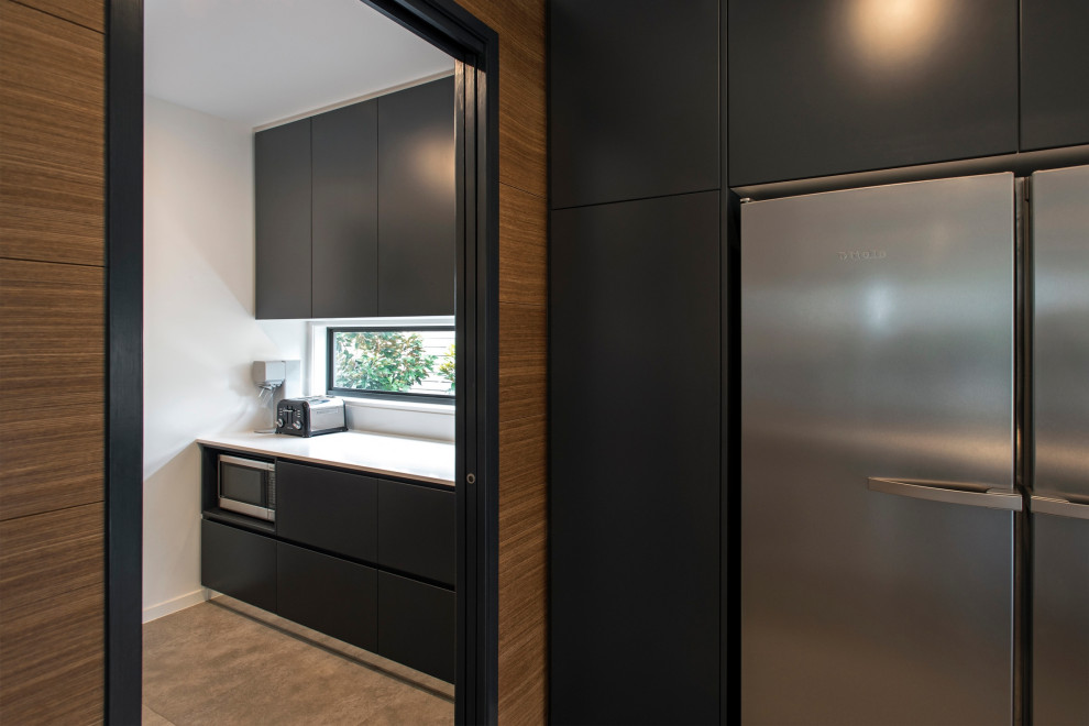 Design ideas for a contemporary galley kitchen pantry with black cabinets, window splashback, ceramic floors, grey floor and white benchtop.