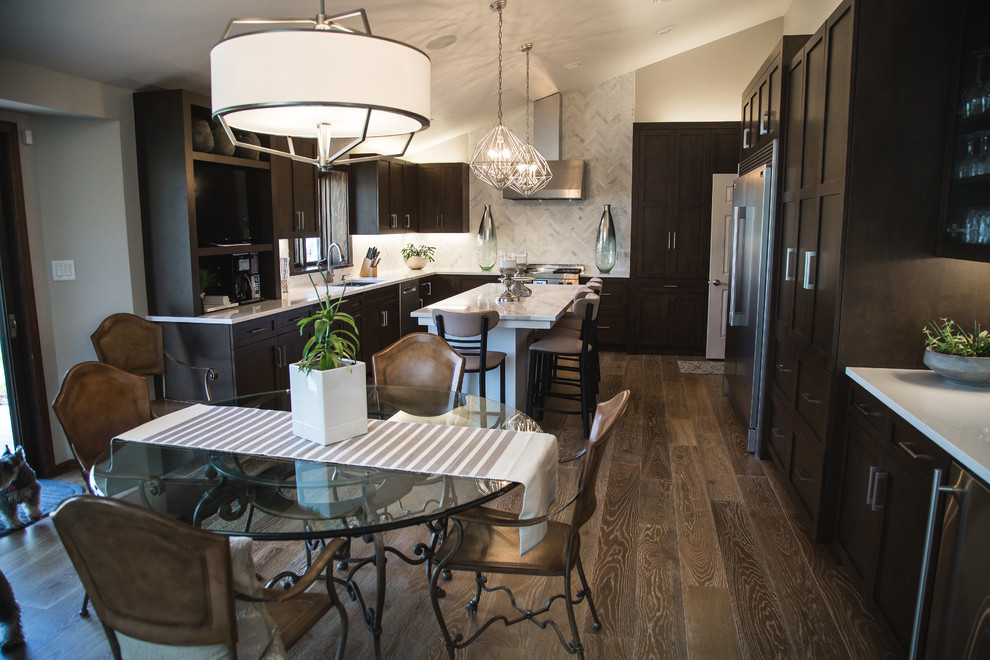 Kitchen - transitional brown floor and medium tone wood floor kitchen idea with recessed-panel cabinets, dark wood cabinets, white backsplash, stainless steel appliances, marble backsplash, an island and quartz countertops