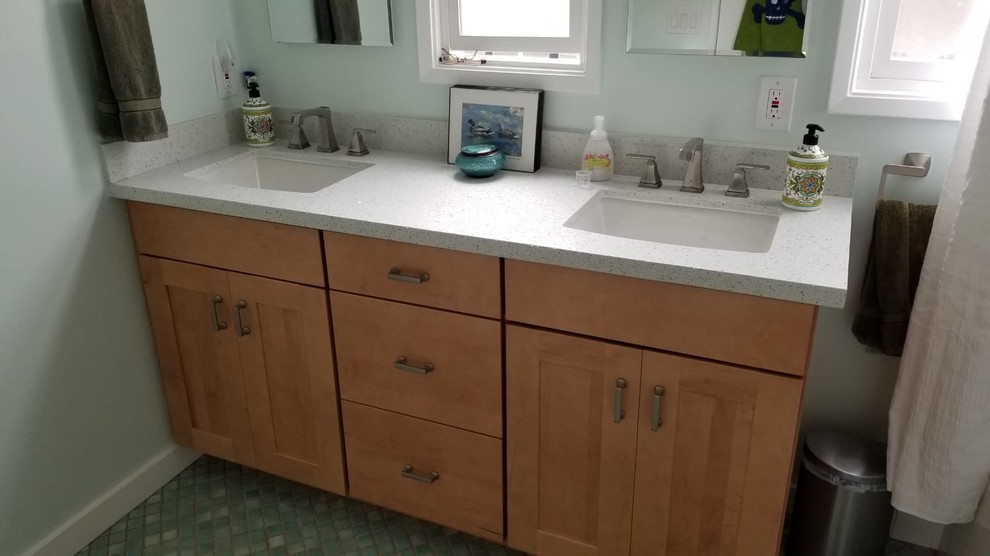 This is an example of a mid-sized transitional 3/4 bathroom in San Francisco with shaker cabinets, light wood cabinets, white benchtops, an undermount sink, recycled glass benchtops, ceramic floors, green floor, an alcove tub, a shower/bathtub combo, a two-piece toilet, white tile, green walls and a shower curtain.