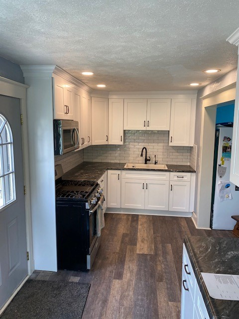 Small transitional l-shaped eat-in kitchen photo with a single-bowl sink, white cabinets, laminate countertops, white backsplash and ceramic backsplash