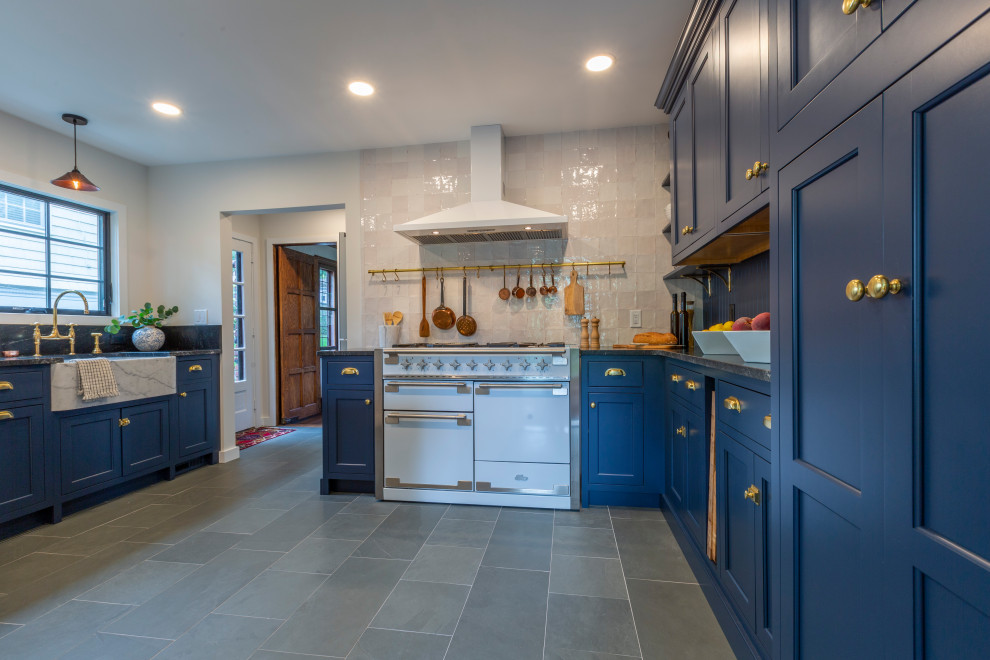 Enclosed kitchen - small french country u-shaped slate floor and gray floor enclosed kitchen idea in New York with a farmhouse sink, shaker cabinets, blue cabinets, granite countertops, white backsplash, white appliances, no island and black countertops