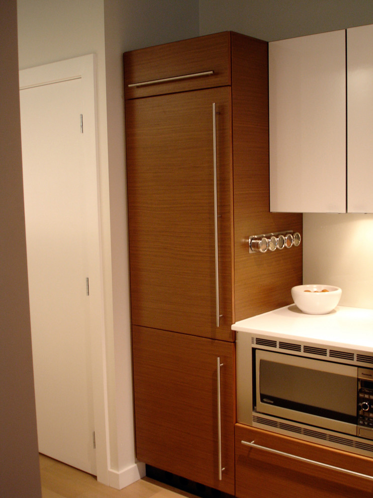 Photo of a contemporary eat-in kitchen in Portland with recessed-panel cabinets, medium wood cabinets and panelled appliances.