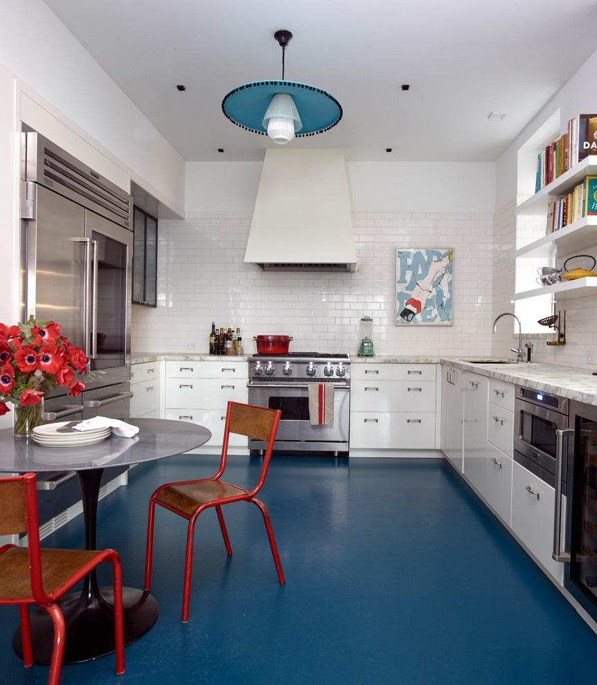 Photo of a contemporary u-shaped eat-in kitchen in New York with an undermount sink, flat-panel cabinets, white cabinets, white splashback, subway tile splashback, stainless steel appliances, blue floor and grey benchtop.