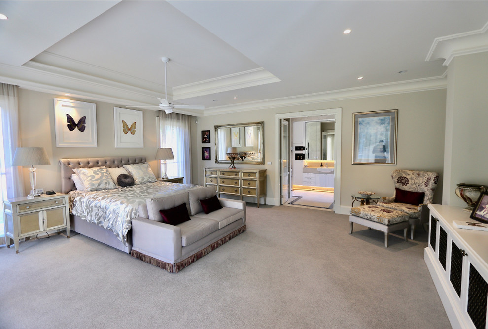 Photo of a large traditional master bedroom in Melbourne with beige walls, carpet, no fireplace and beige floor.