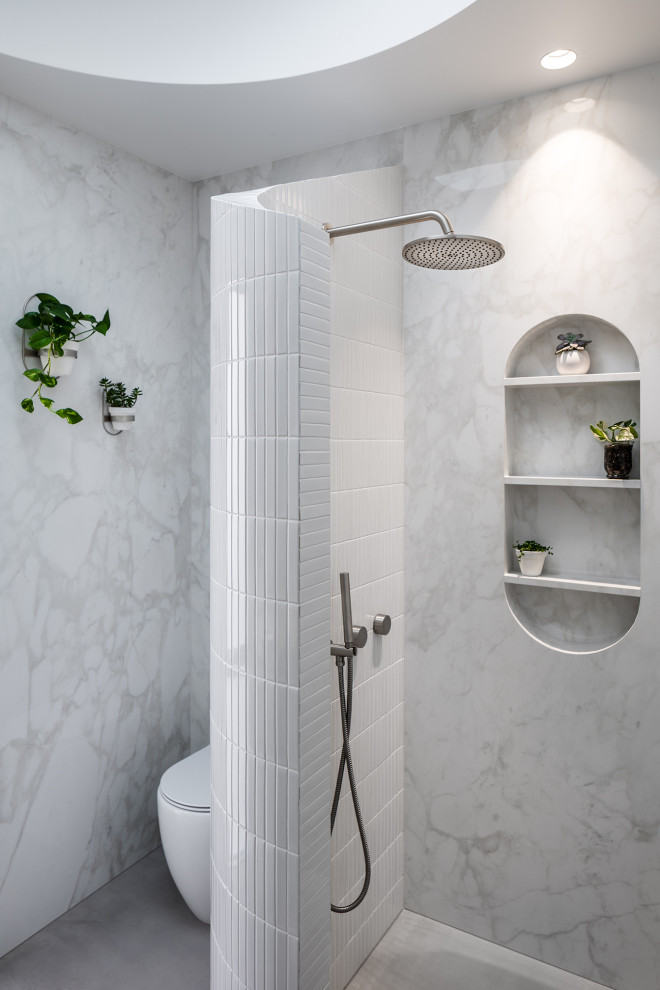 Идея дизайна: маленькая ванная комната в современном стиле с белой плиткой, душевой кабиной, открытым душем, нишей, тумбой под одну раковину и напольной тумбой для на участке и в саду