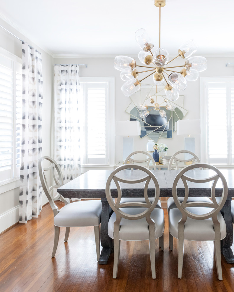 Transitional dining room in Charlotte with white walls, medium hardwood floors and brown floor.