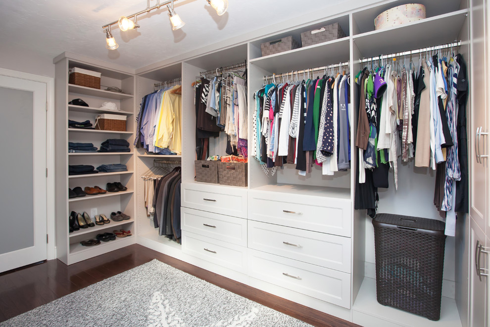 Large contemporary gender-neutral walk-in wardrobe in Boston with flat-panel cabinets, white cabinets and dark hardwood floors.