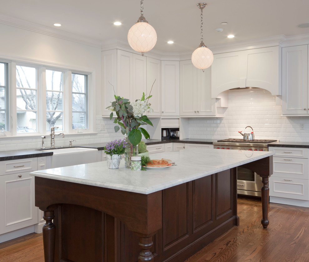 Photo of a traditional kitchen in San Francisco with white cabinets, white splashback and with island.