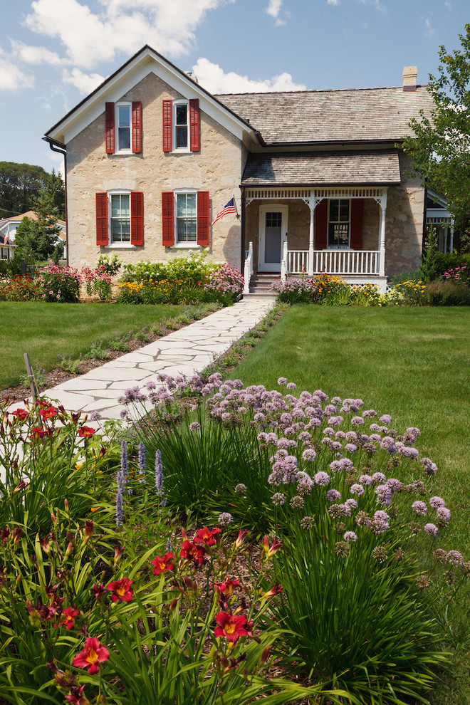 Inspiration for a mid-sized country front yard full sun xeriscape for summer in Milwaukee with natural stone pavers and a garden path.