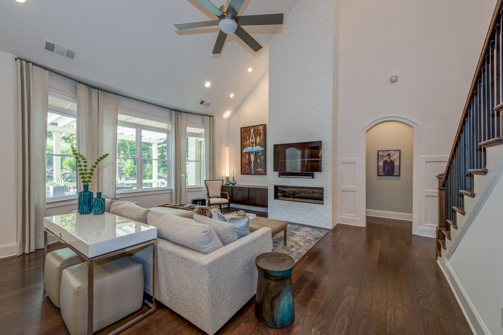 Photo of a contemporary open concept family room in Atlanta with white walls, dark hardwood floors, a brick fireplace surround and a wall-mounted tv.