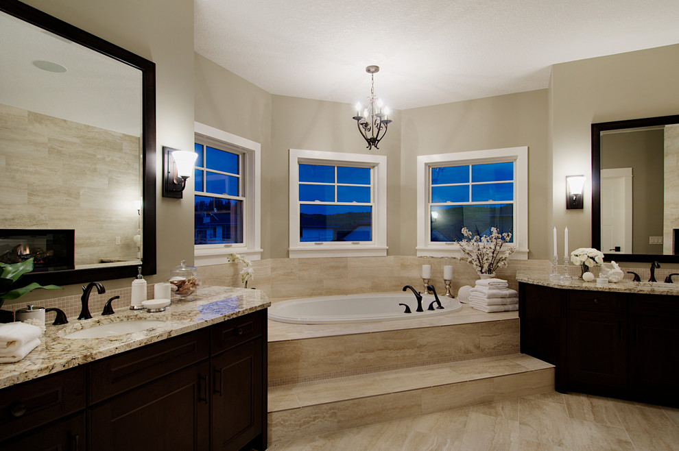 Design ideas for a traditional bathroom in Calgary with an undermount sink, flat-panel cabinets, dark wood cabinets, quartzite benchtops, a drop-in tub, beige tile, porcelain tile, grey walls and porcelain floors.