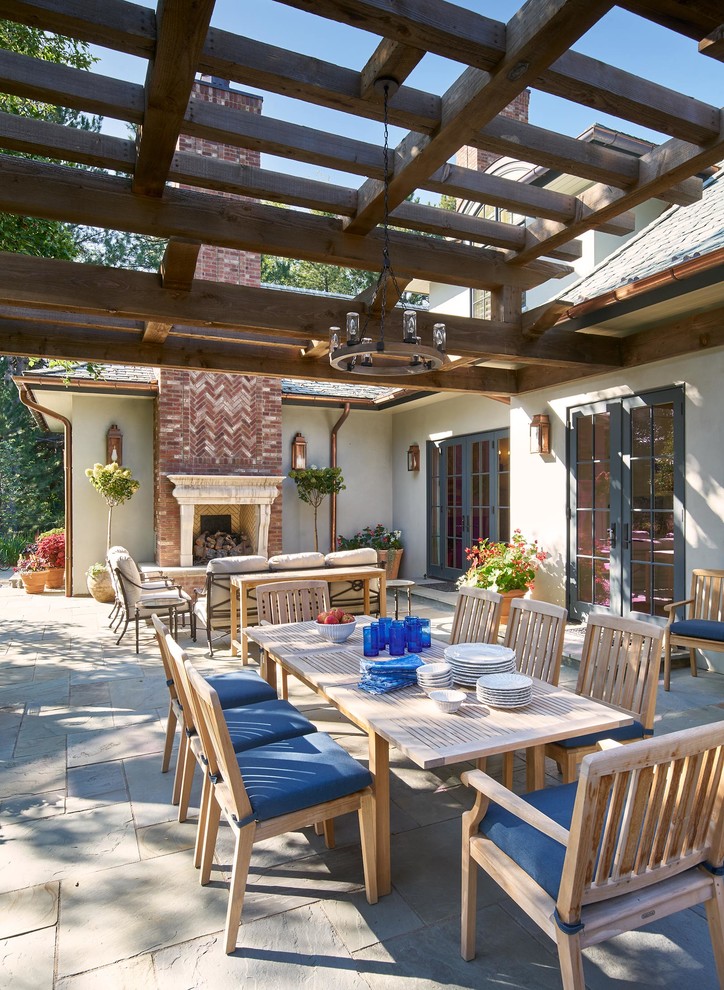 Photo of a large traditional backyard patio in Denver with with fireplace, natural stone pavers and a pergola.