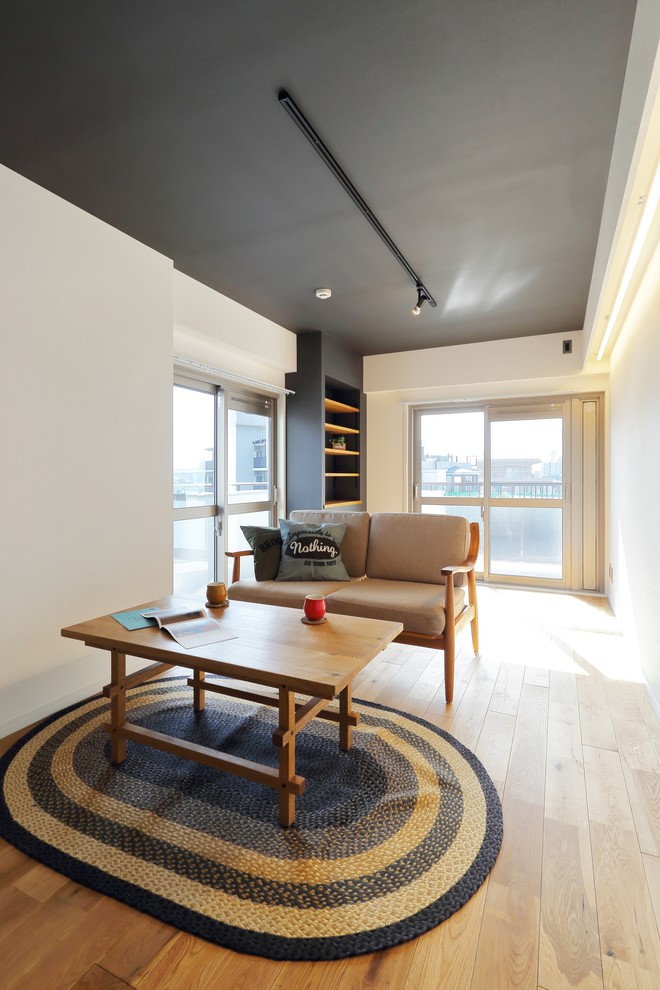 Small industrial living room in Tokyo with white walls, light hardwood floors and brown floor.