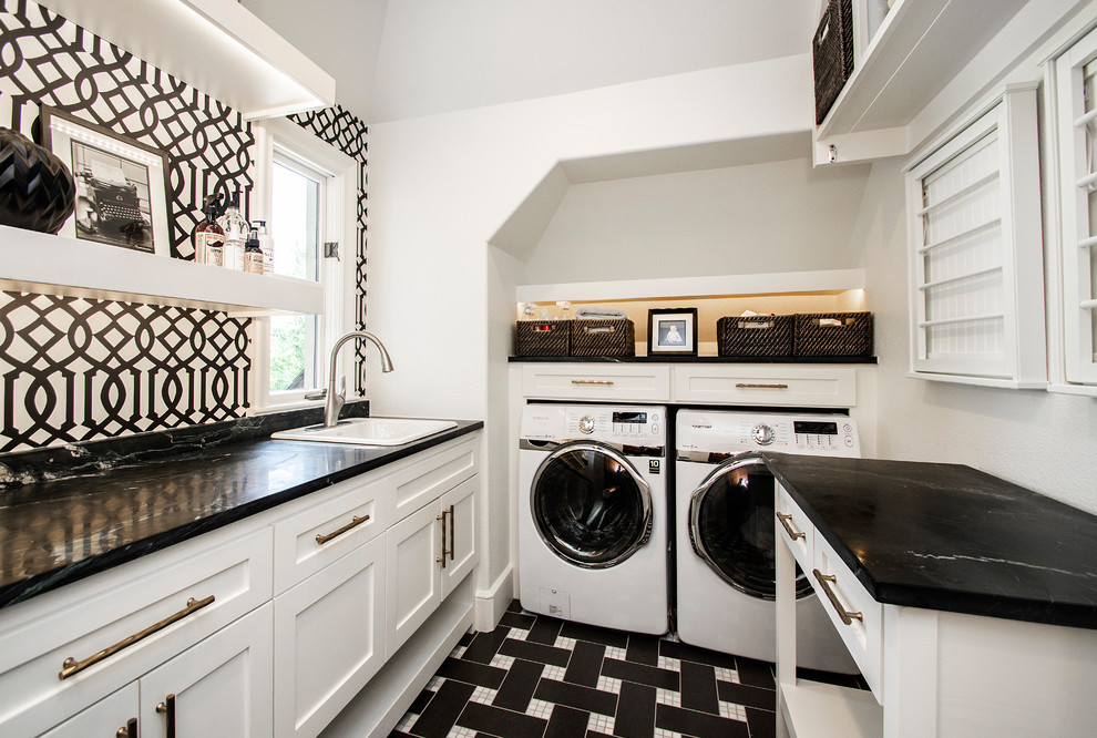Inspiration for a large traditional dedicated laundry room in Dallas with a drop-in sink, white cabinets, soapstone benchtops, porcelain floors, a side-by-side washer and dryer, multi-coloured floor, black benchtop, shaker cabinets and multi-coloured walls.