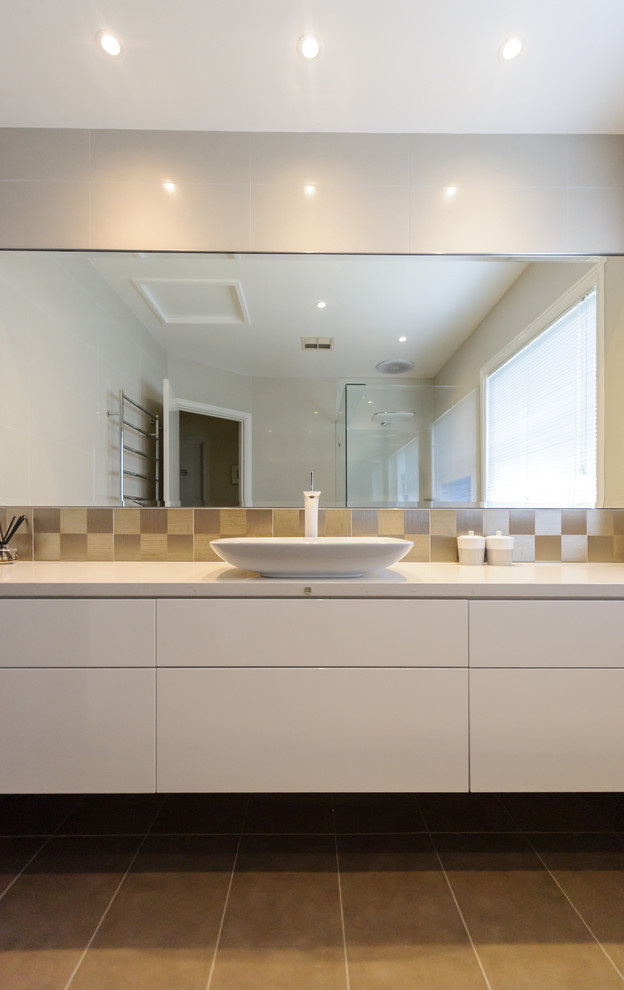 This is an example of a small contemporary bathroom in Melbourne with a vessel sink, flat-panel cabinets, white cabinets, engineered quartz benchtops, an open shower, porcelain tile, porcelain floors, multi-coloured tile and beige walls.