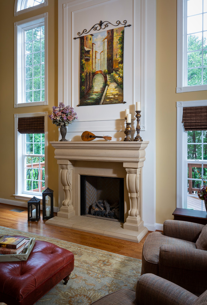 This is an example of a mid-sized country formal enclosed living room with beige walls, medium hardwood floors, a standard fireplace, a plaster fireplace surround, a freestanding tv and brown floor.