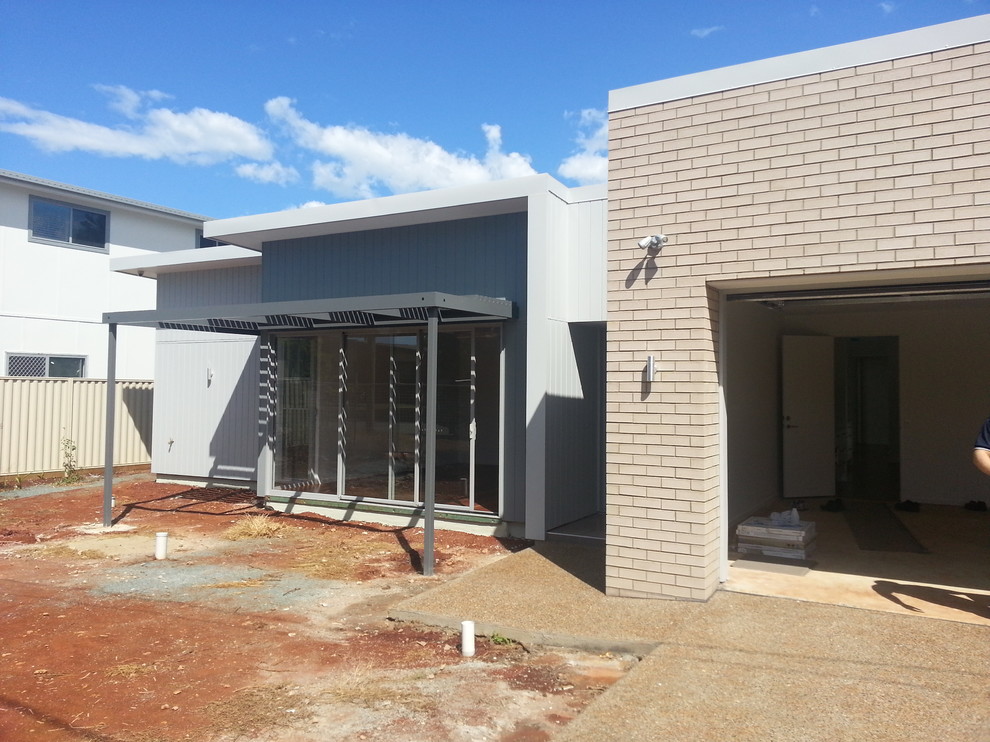 Mid-sized contemporary one-storey brick grey exterior in Brisbane with a flat roof.