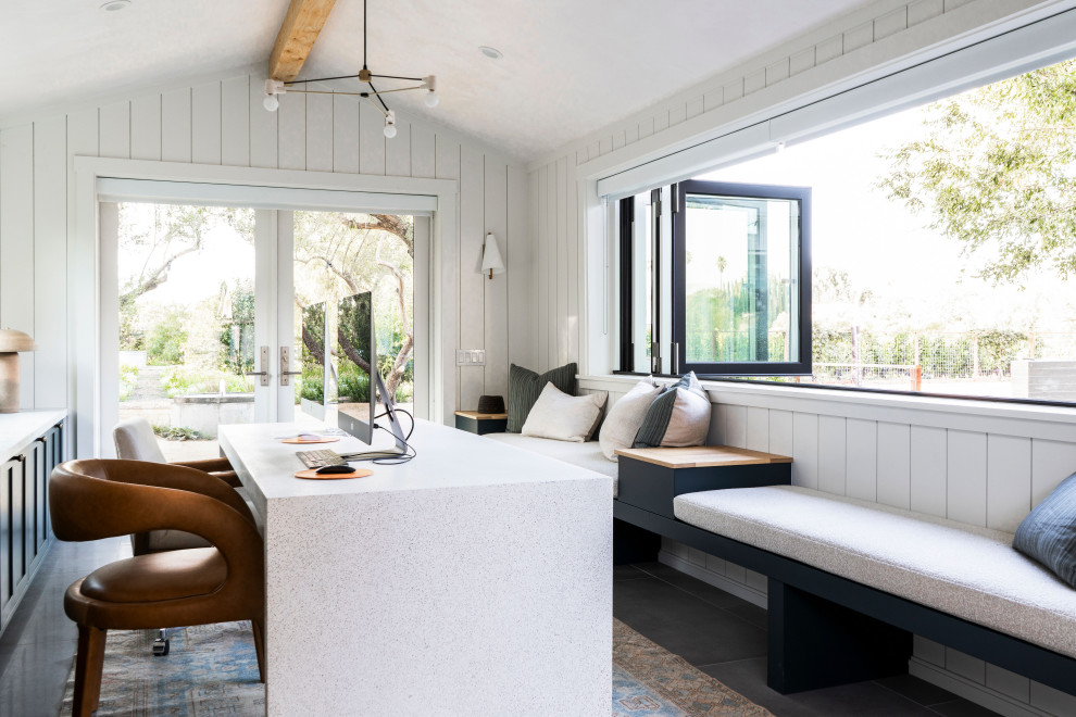 Example of a transitional freestanding desk concrete floor, gray floor, exposed beam, vaulted ceiling and shiplap wall home office design in San Luis Obispo with white walls and no fireplace