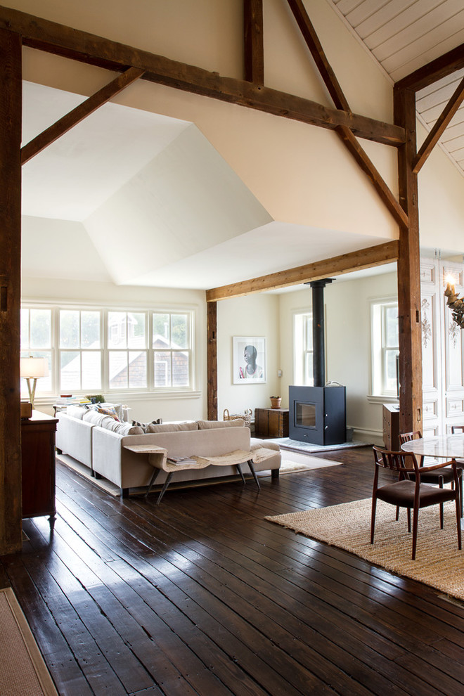 Large country living room in Chicago with white walls, dark hardwood floors and a wood stove.