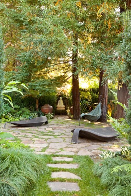 This is an example of a large asian backyard partial sun formal garden for spring with a container garden and natural stone pavers.