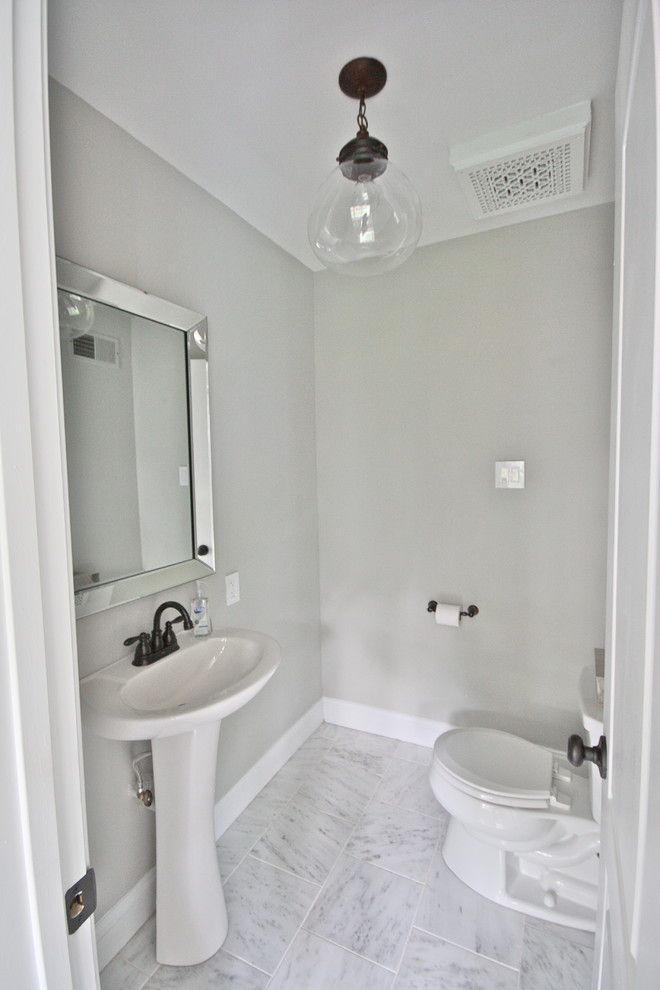 Photo of a large transitional 3/4 bathroom in St Louis with a pedestal sink, a one-piece toilet, white tile, grey walls and marble floors.