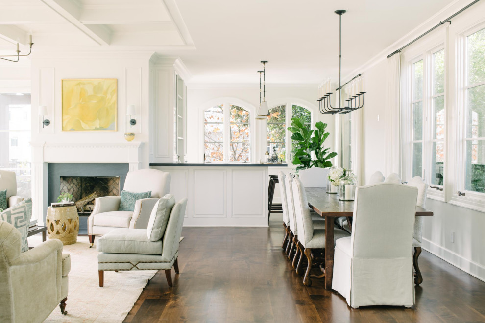This is an example of a beach style dining room in Los Angeles with white walls, dark hardwood floors and brown floor.