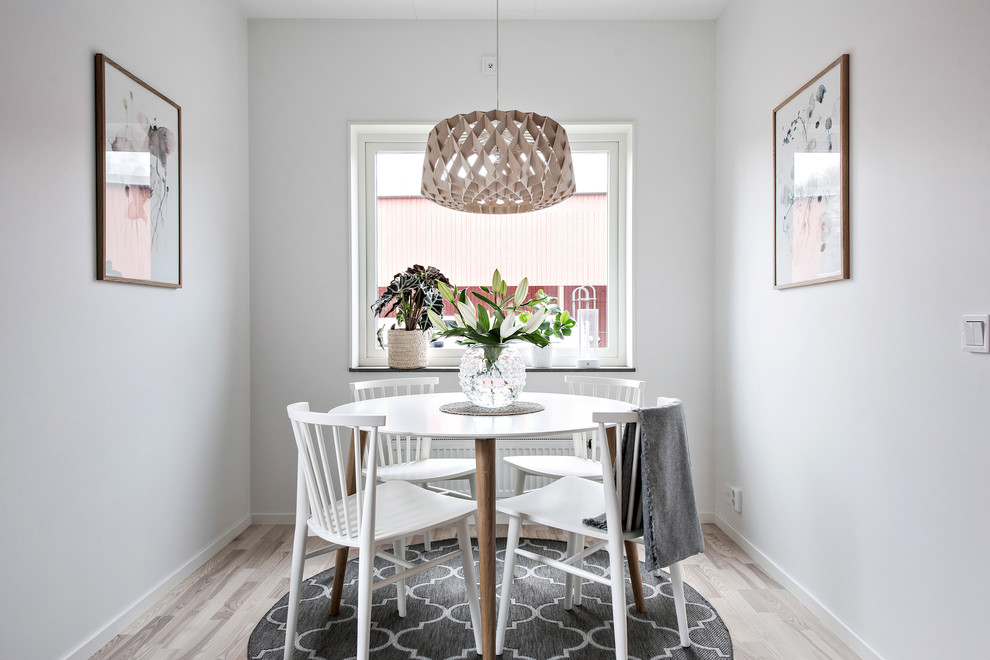 Photo of a small scandinavian separate dining room in Gothenburg with white walls, light hardwood floors and beige floor.