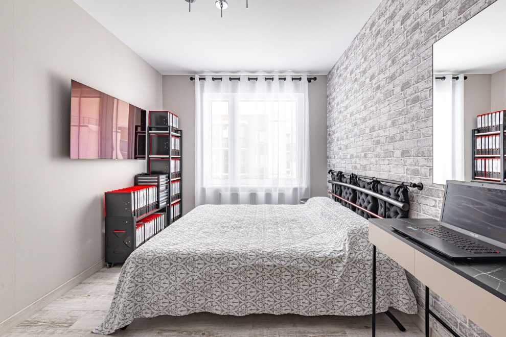 Стильный дизайн: хозяйская, серо-белая спальня в современном стиле с серыми стенами, полом из ламината, серым полом и обоями на стенах - последний тренд